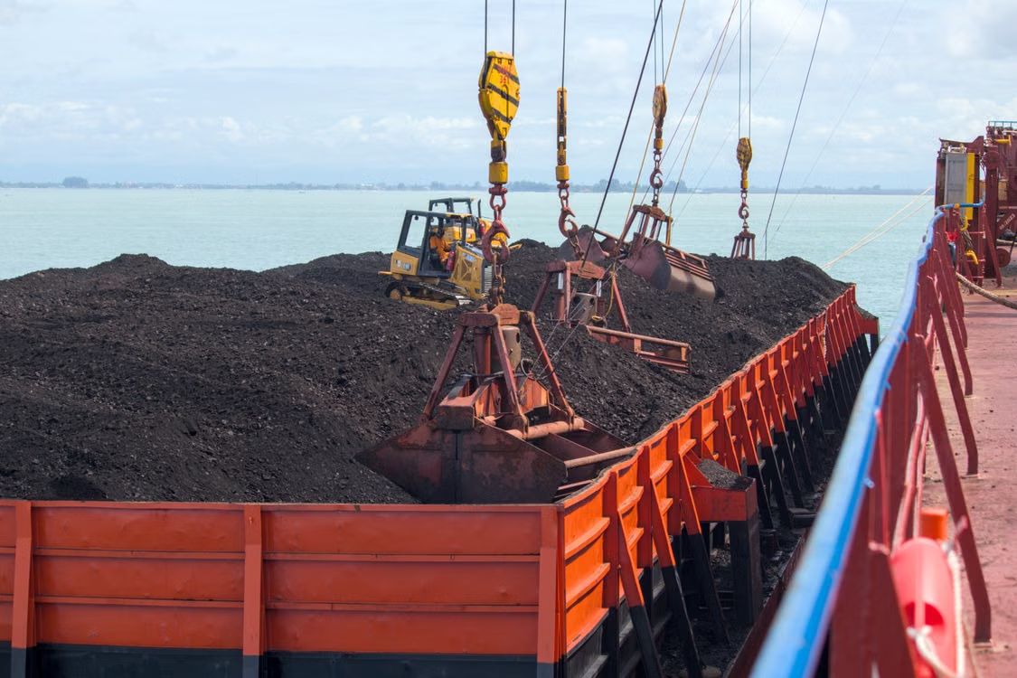 Grab cranes loading iron ore into a vessel for export to China